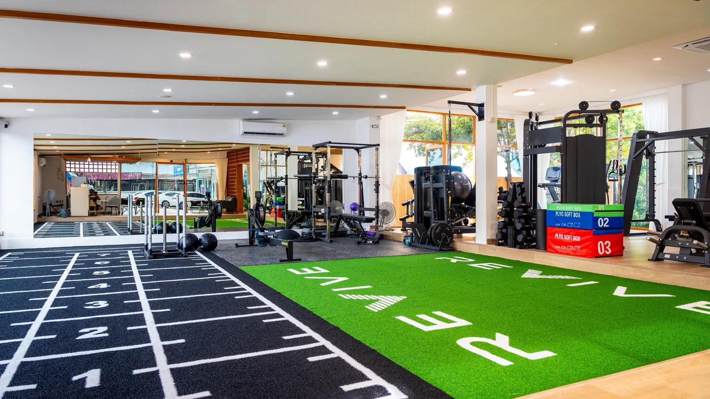 Commercial gym divided into custom turf lanes and rubber flooring zones