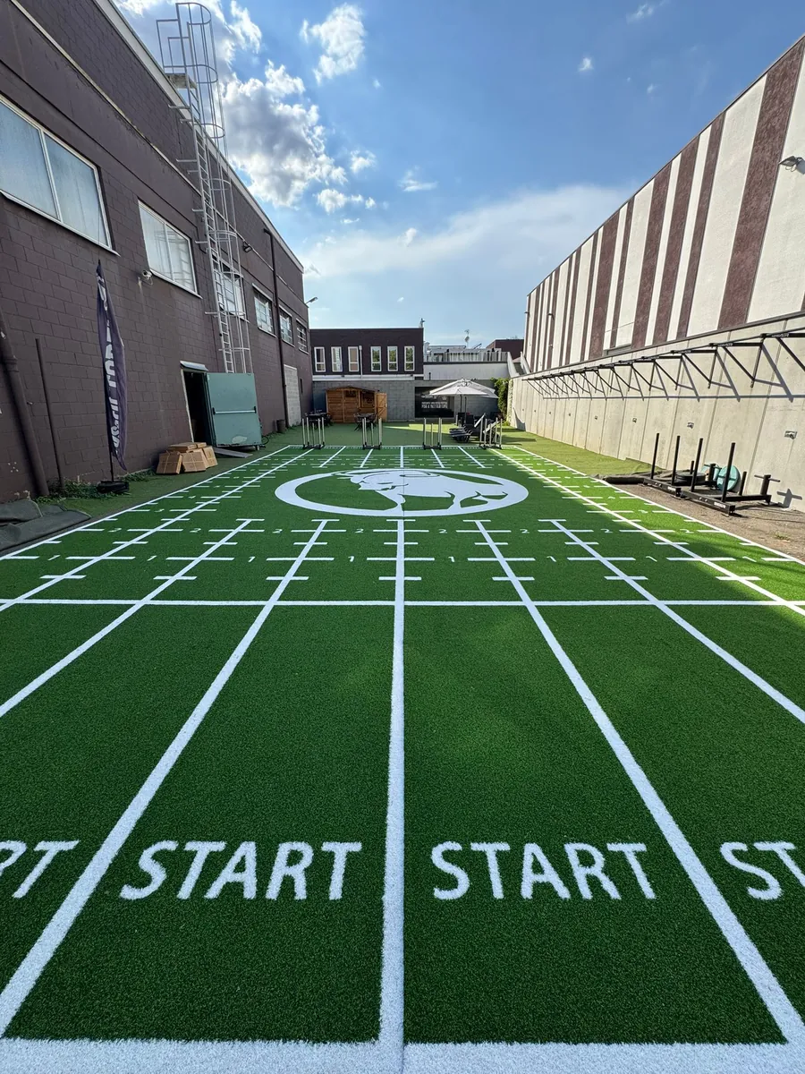 Completed commercial gym custom turf installation showing aligned graphics and equipment zones