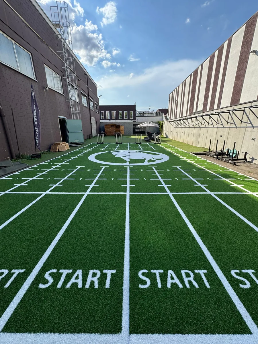 Completed outdoor custom gym turf project with multiple sled training lanes
