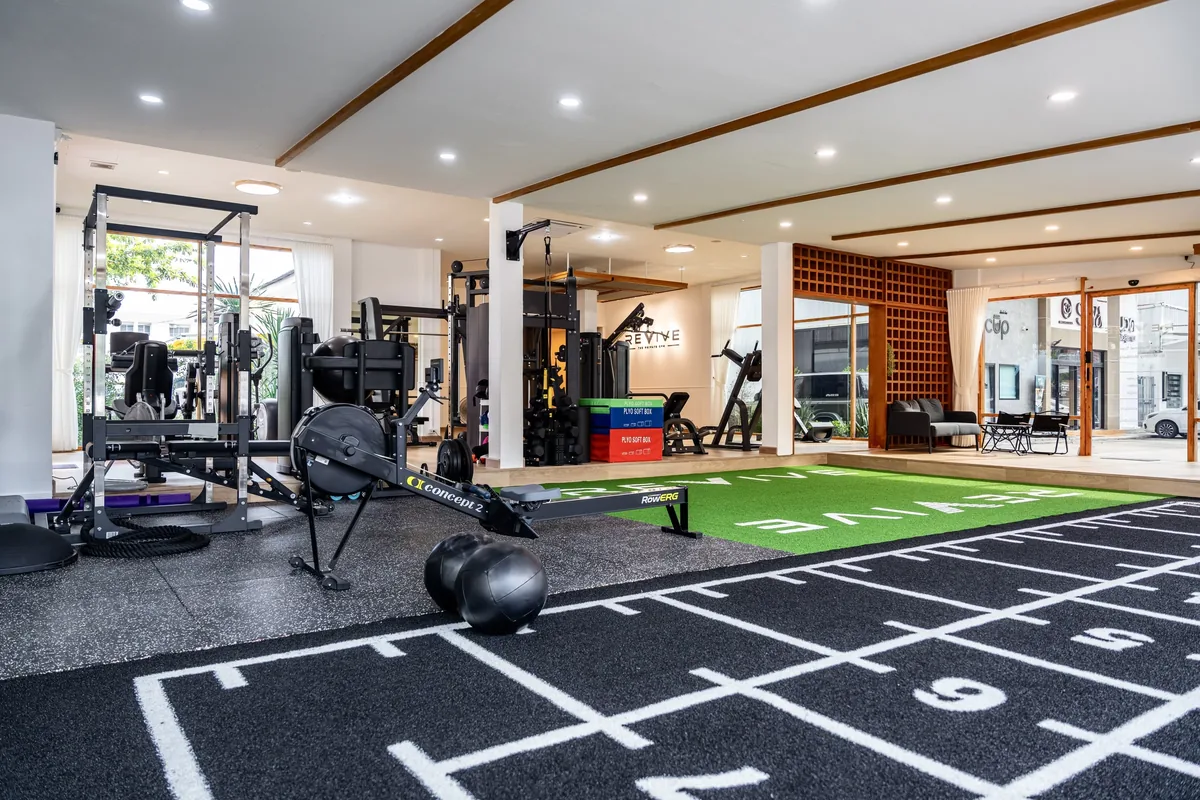 Sled track turf integrated with rowing and strength equipment in a commercial gym