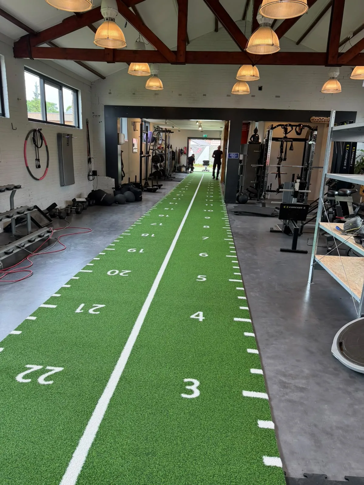 Long green numbered gym turf track installed through a Netherlands functional training facility