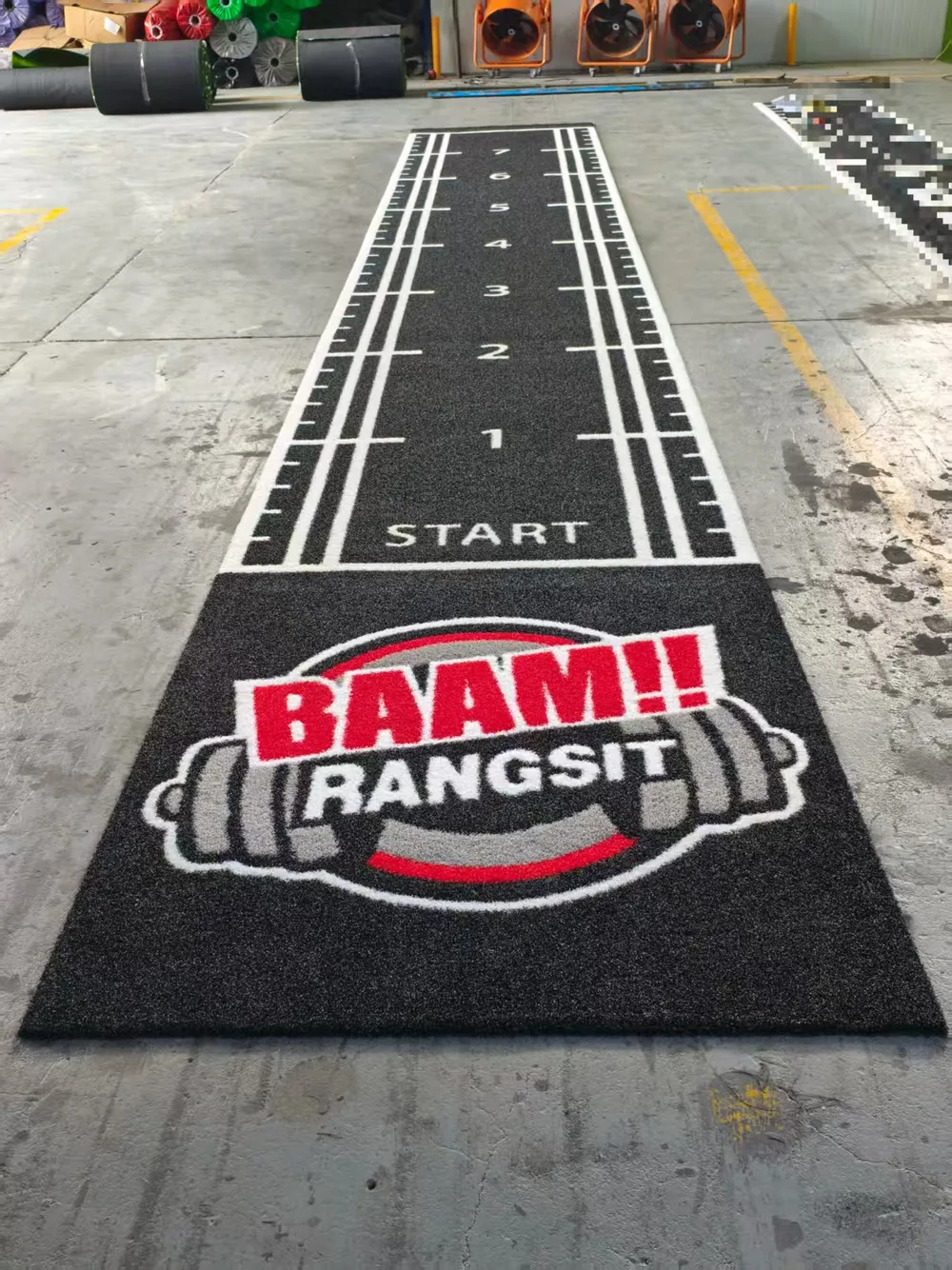 Finished black custom turf laid out on the factory floor