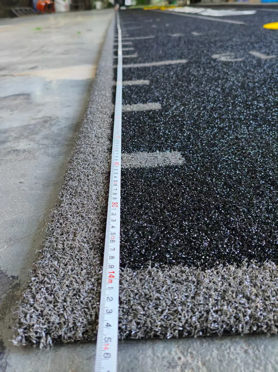 Tape measure confirming the 14m length of the UK custom gym turf project