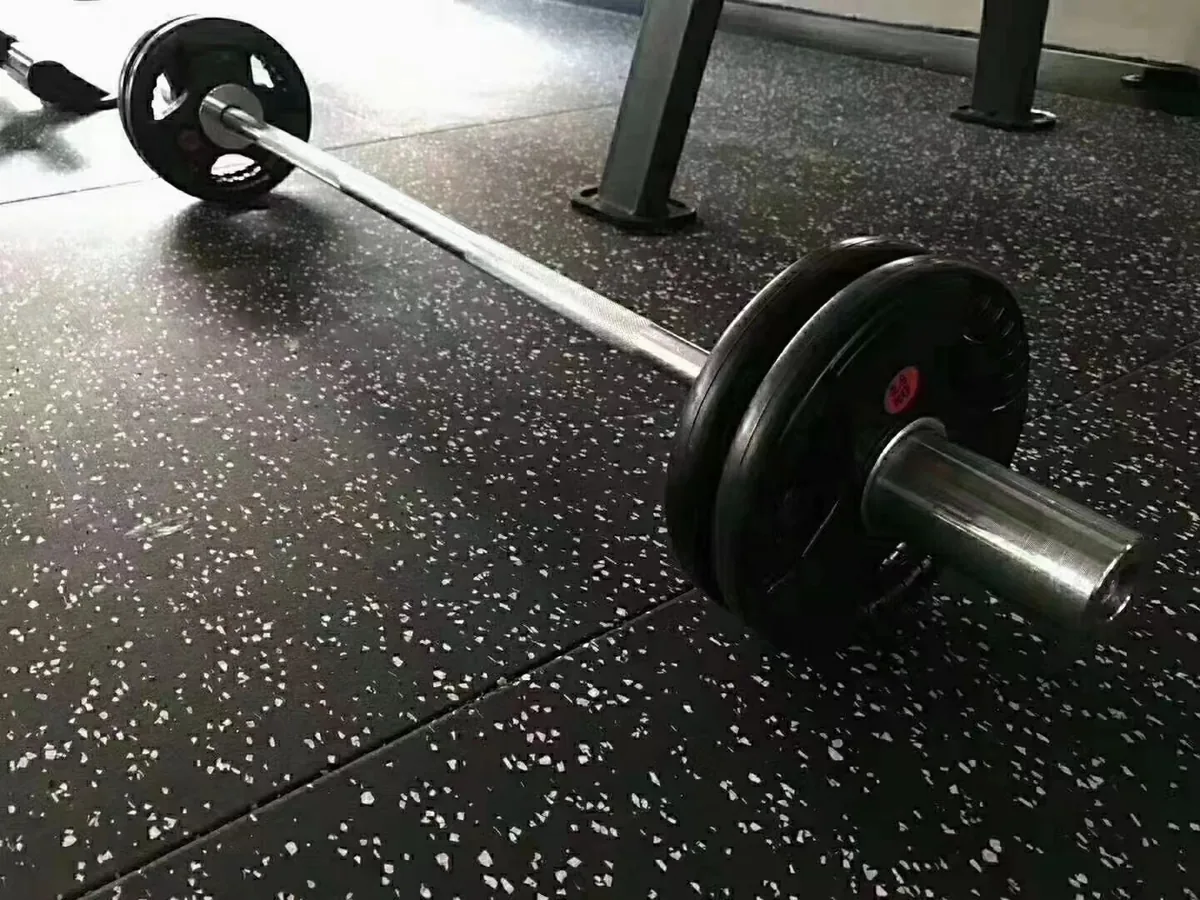 Installed speckled rubber gym tiles in a commercial free-weight area